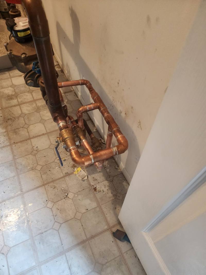 New copper piping and brass ball valves installed beside a water meter