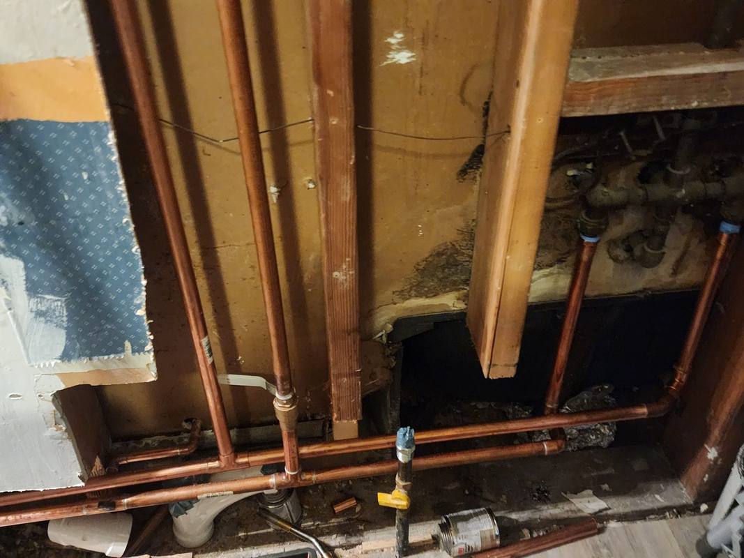 New copper supply lines run through an opened wall during a repipe